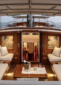 the inside of a boat with couches, tables and chairs on it's deck