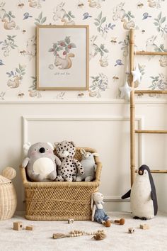 there is a basket with stuffed animals in it next to a wallpapered wall