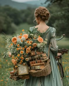 a woman holding a basket full of flowers and books in her hand while walking through a field