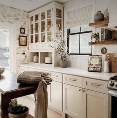 a kitchen filled with lots of white cupboards and counter top next to a window