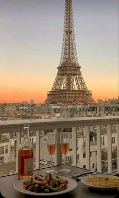 two plates of food on a table in front of the eiffel tower