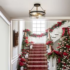 a staircase decorated for christmas with red and silver decorations