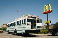 a white bus parked in front of a mcdonald's