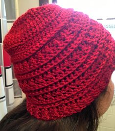 a woman wearing a red crocheted beanie hat