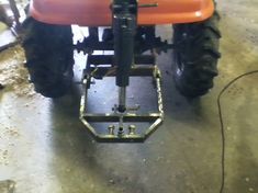 an orange and black tractor sitting in a garage