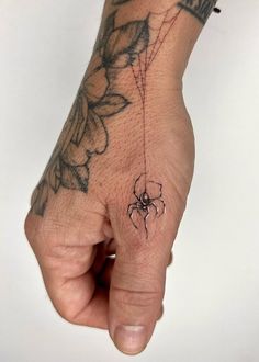 a hand with a spider tattoo on it