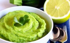 a white bowl filled with green guacamole and garnished with cilantro