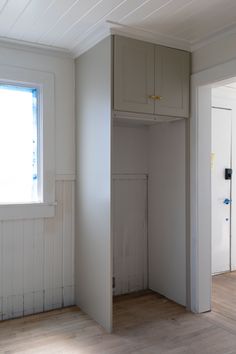 an empty room with white walls and wood flooring in the foreground is a closet