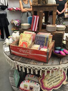 two women standing in front of a table with cards and other items on top of it