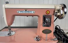 an old pink sewing machine sitting on top of a table