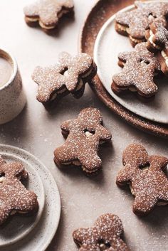 some cookies are sitting on plates next to a cup and saucer