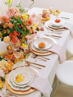 the table is set with flowers and plates