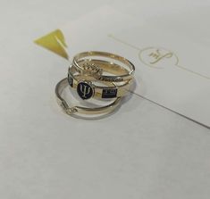 three different rings sitting on top of each other next to a piece of yellow paper