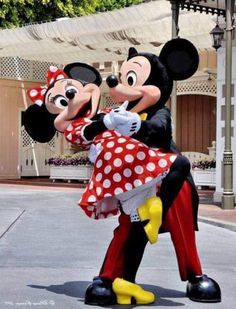 two mickey and minnie mouse characters hugging each other