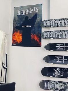 several skateboards are hanging on the wall in front of a sign that reads,