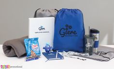 the contents of a travel bag sitting on top of a white table next to a blue bag