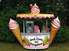 an ice cream stand with pineapples and pink icing on it's sides