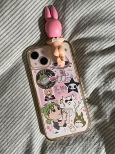 a cell phone case with an anime character on it sitting on top of a bed