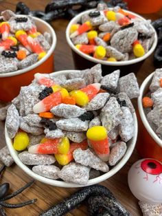 halloween muddy buddies in white bowls with candy on the side and text overlay that reads,