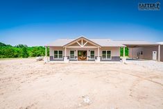 a large house sitting on top of a dirt field