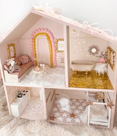 a doll house with all the furniture and accessories in pink, gold and white colors