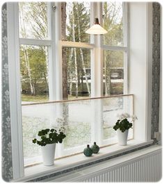 three potted plants are sitting on the window sill