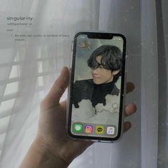 a person holding up an iphone with the image of a boy on it