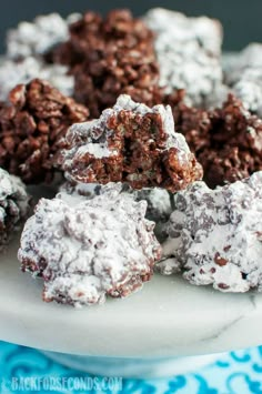 chocolate crinkle cookies on a plate with powdered sugar and brownie holes