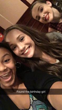 three girls are smiling and posing for the camera