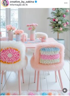 two pink chairs sitting next to each other in front of a table with flowers on it