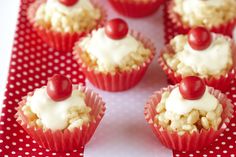 cupcakes with cherries and white frosting on a red polka dot plate