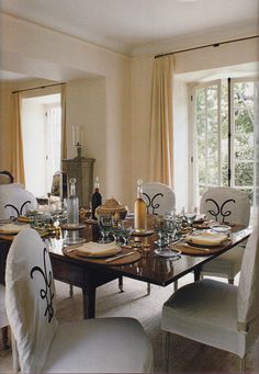 the dining room table is set with white chairs and place settings for four people to sit at