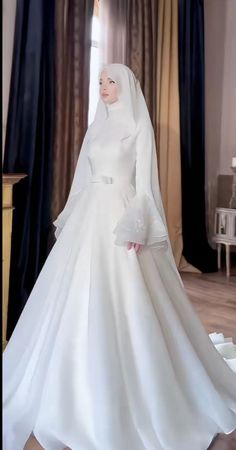 a woman in a white wedding dress and veil