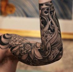 a man's arm with an intricate tattoo design on it