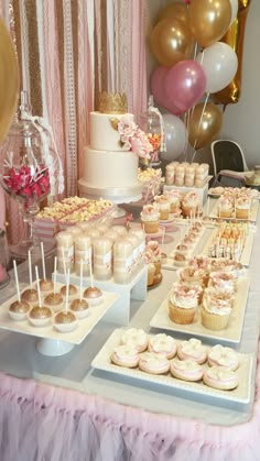 a table topped with lots of cupcakes and cake