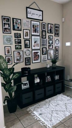 a living room with pictures on the wall and a large rug in front of it