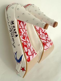 "Customized wedding shoes for bride with red and blue colors. Hand painted bridal shoes designed for a vintage Rockabilly wedding. Unique wedding shoes, great idea for wedding gift or gifts for her. Ivory bridal shoes are designed with red hearts on the backs that say \"Just Married\". Names of the bride and groom and their wedding date are written on the sides with a 50s rockabily font and the heels are decorated with scattered rhinestones. A vintage red car is pictured on one toe, and on the o Colorful Wedding Shoes Funky, Unusual Shoes For Bride, Wedding Dress With Bold Shoes, De Potage Wedding Shoes Loved Ones, Wedding Disney Shoes, Red Bridal Shoes Veaul, Color Wedding Shoes Bride, Wedding Dress Bright Heels, Christmas Bride Red Shoes