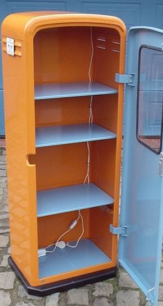 an orange and blue storage cabinet sitting on the side of a road