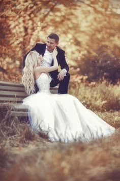 a bride and groom are sitting on a bench