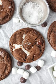 chocolate cookies with marshmallows and sea salt are on the table next to each other