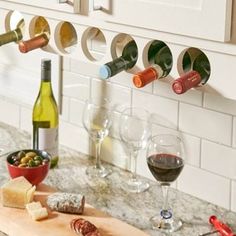 several wine bottles and glasses on a kitchen counter