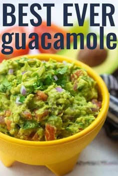 a yellow bowl filled with guacamole on top of a table