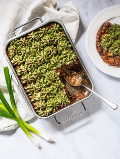 a casserole dish with broccoli and beans in it on a table