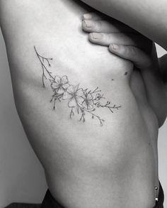 a black and white photo of a woman's stomach with flowers on it