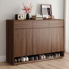 there is a wooden cabinet with shoes on the top and bottom shelf next to it