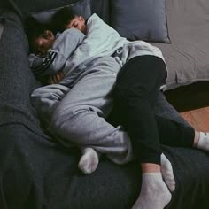 a man sleeping on top of a black couch