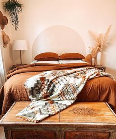 a bed sitting in a bedroom next to a window with a blanket on top of it