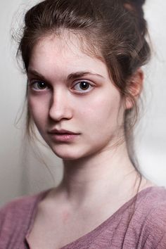 a young woman is posing for the camera with her hair in a messy updo