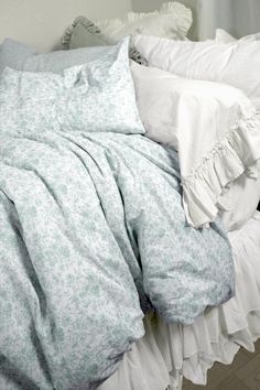 an unmade bed with white sheets and ruffles on the pillowcase is shown