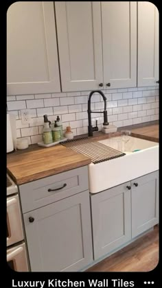 a kitchen with white cabinets and wooden counter tops, including a large farmhouse style sink